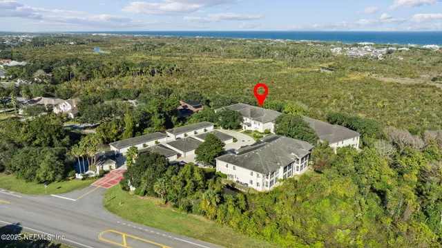 an aerial view of a house with a yard and large trees