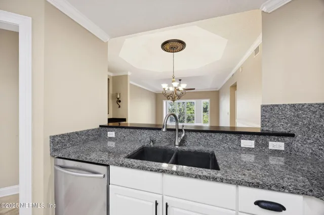a kitchen with a sink and chandelier