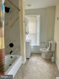 a bathroom with a tub a toilet and a shower