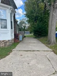 a view of a backyard with brick wall and plants