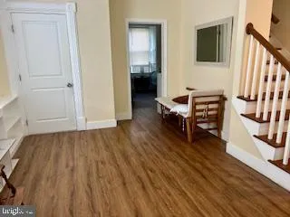 a view of a hallway with wooden floor and staircase