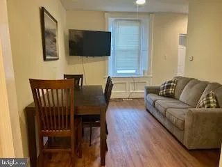 a living room with furniture a flat screen tv and kitchen view