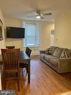 a living room with furniture a flat screen tv and kitchen view