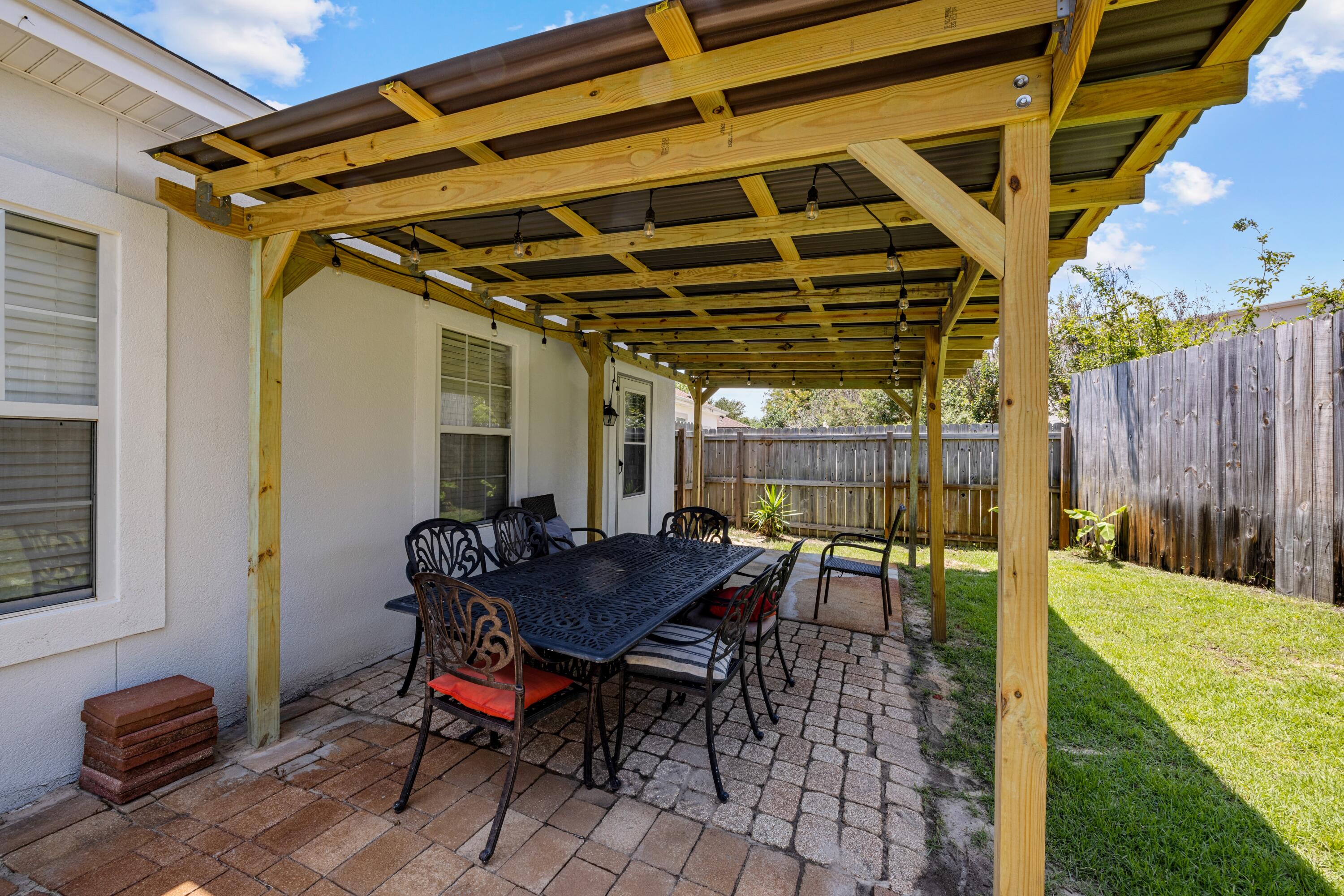 96 Trista Terrace Court Destin, FL 32541 - Photo 34 of 36 a view of a backyard with table and chairs with wooden floor