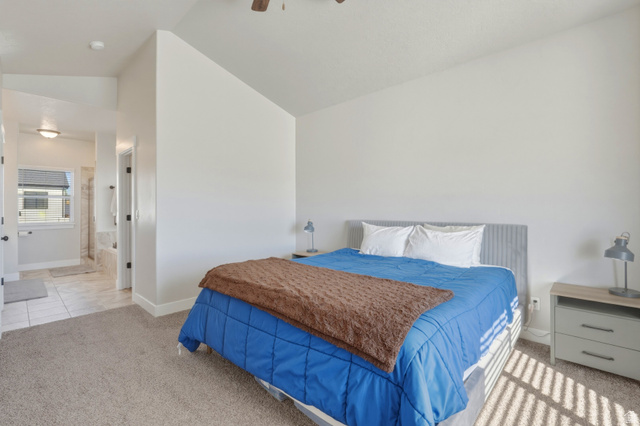 836 South 250 West Vernal, UT 84078 - Photo 10 of 56 Bedroom featuring light carpet, lofted ceiling, ensuite bathroom, and a ceiling fan