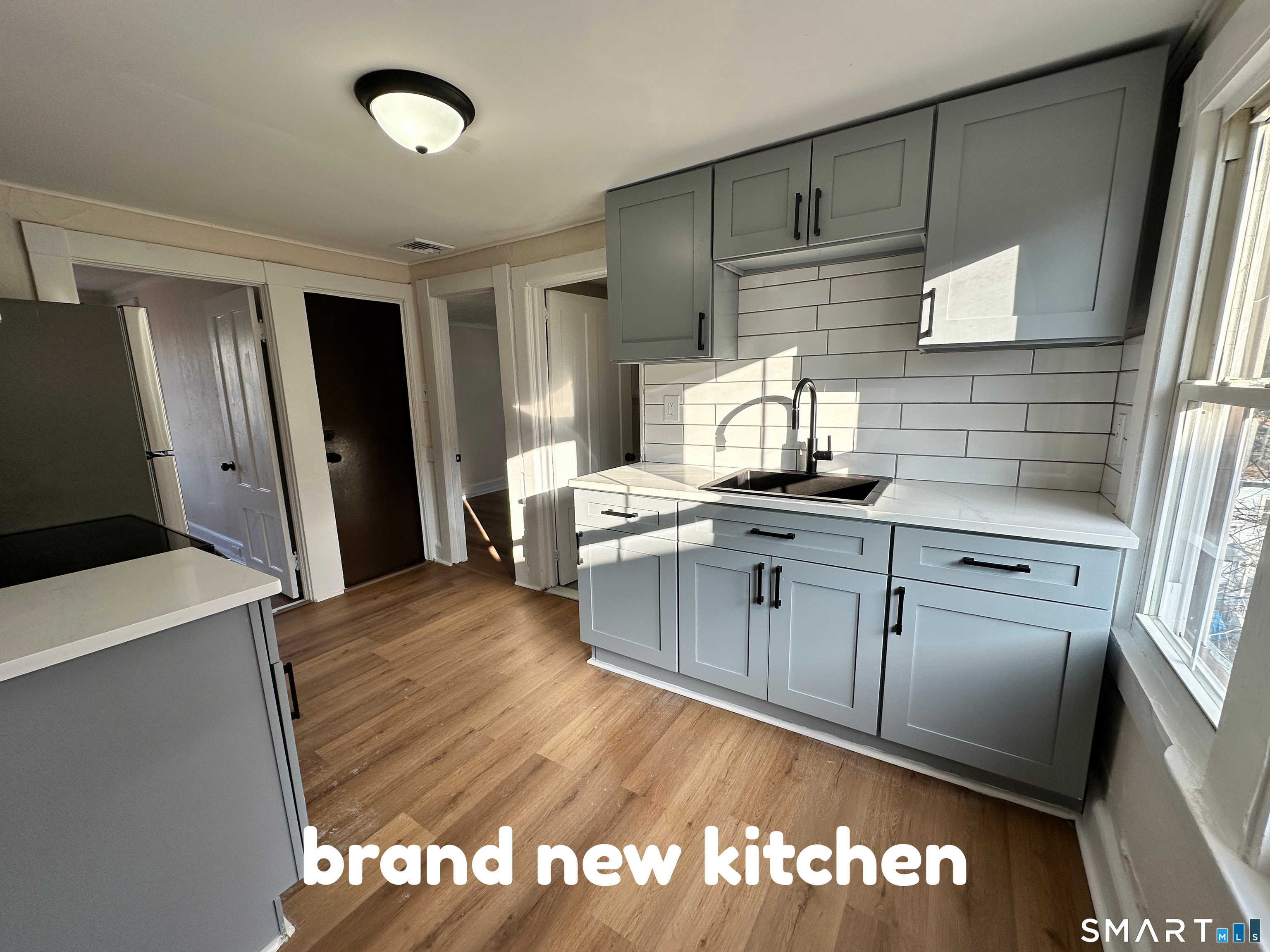 a kitchen with granite countertop a stove a sink and a refrigerator
