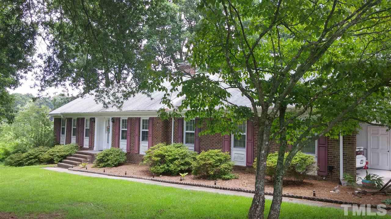 7000 Mitchell Mill Road Zebulon, NC 27597 - Photo 1 of 6 a front view of a house with a yard and potted plants
