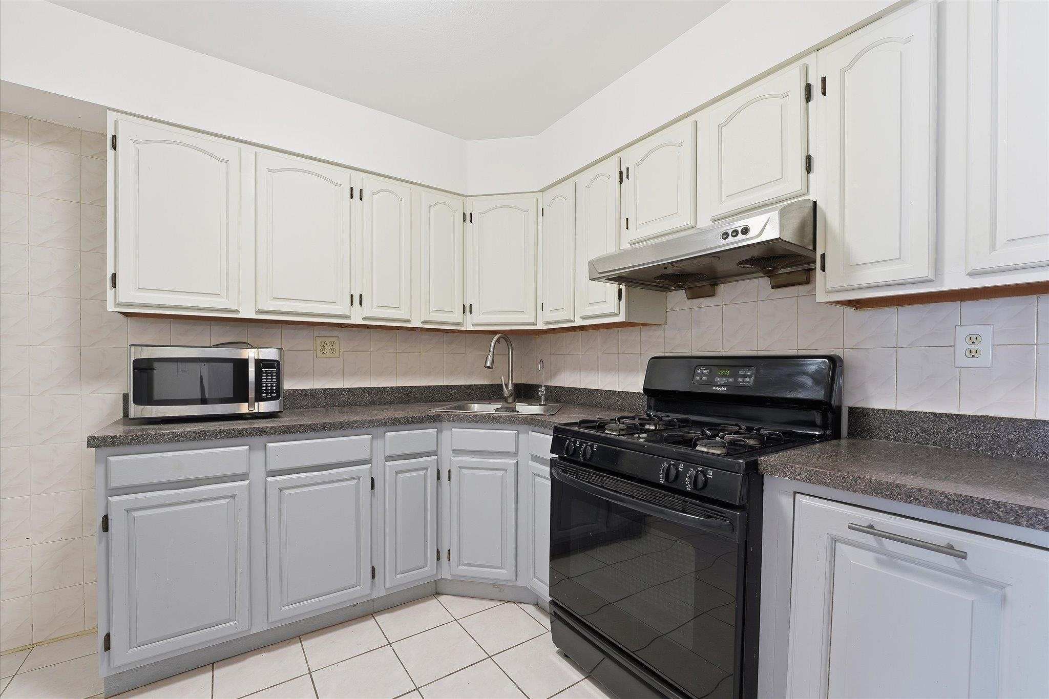 41 Alan Terrace, Unit 1 Jersey City, NJ 07306 - Photo 12 of 16 a kitchen with white cabinets and appliances