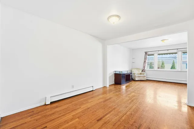 a view of a room with wooden floor and window