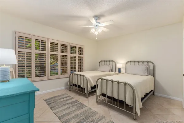 a spacious bedroom with two beds and a chandelier