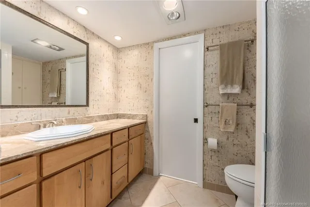 a bathroom with a granite countertop sink toilet and shower