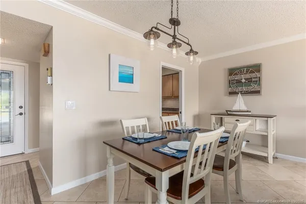 a view of a dining room with furniture and a chandelier fan