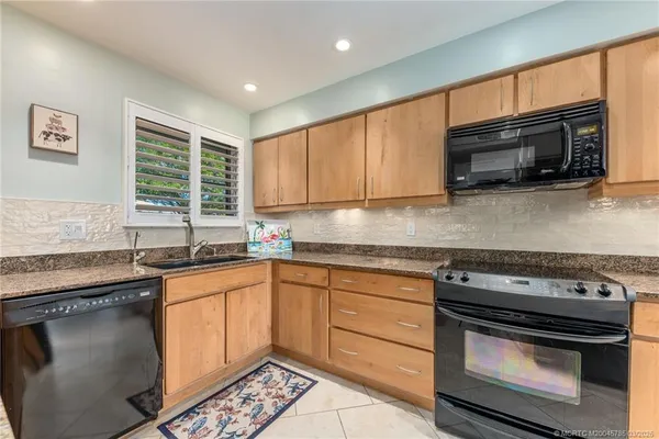 a kitchen with stainless steel appliances granite countertop a stove sink microwave and cabinets