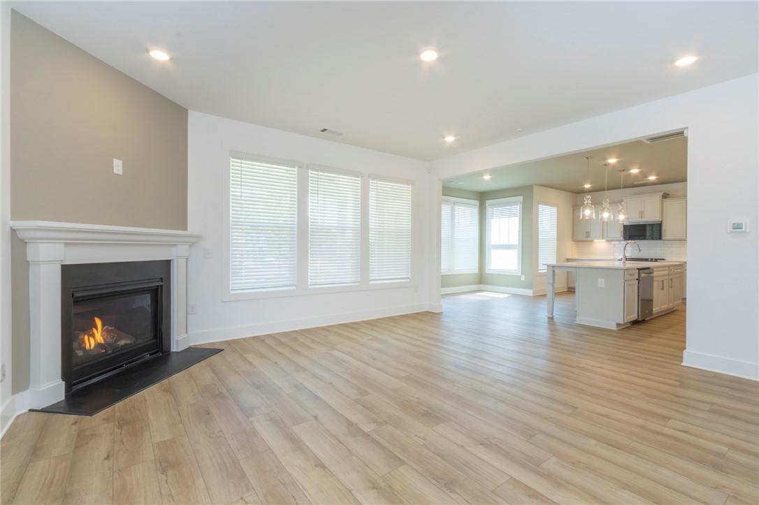 607 WH Kay Lane Anderson, SC 29621 - Photo 5 of 48 A welcoming living area with a cozy fireplace flows seamlessly into a bright, open-plan kitchen.