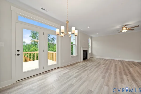 a view of a room with wooden floor fireplace and windows