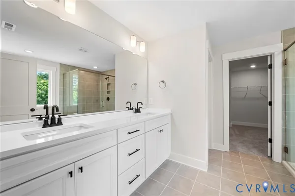 a spacious bathroom with a double vanity sink mirror and shower
