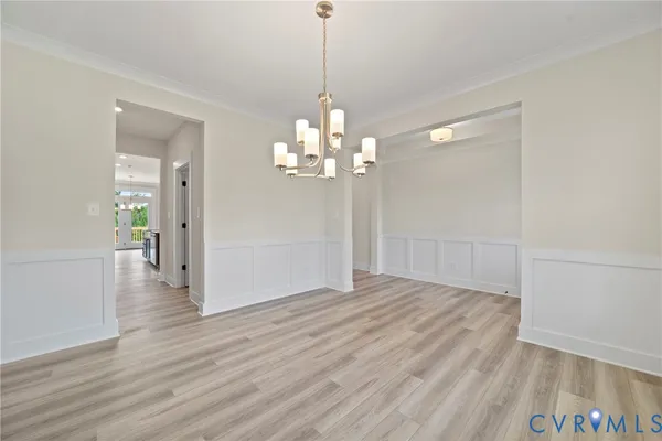 a view of a chandelier in big room with wooden floor