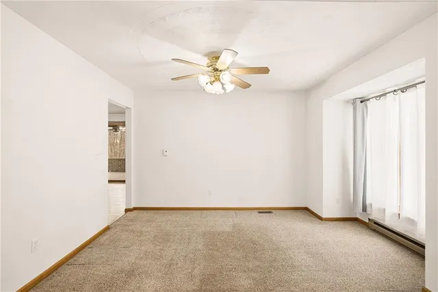 an empty room with closet and a chandelier fan