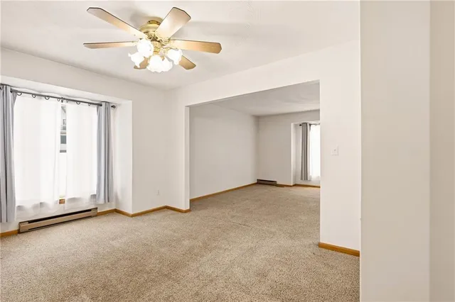 an empty room with a ceiling fan and a window