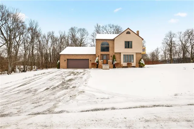 a view of a white house with a yard covered in snow