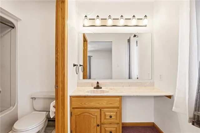an empty room with chandelier fan and windows