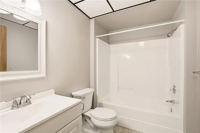 a bathroom with a granite countertop sink a mirror and a shower