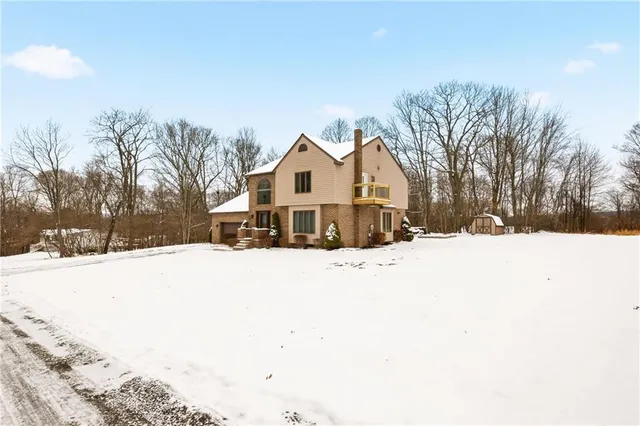 a view of a white house with a snow on the road