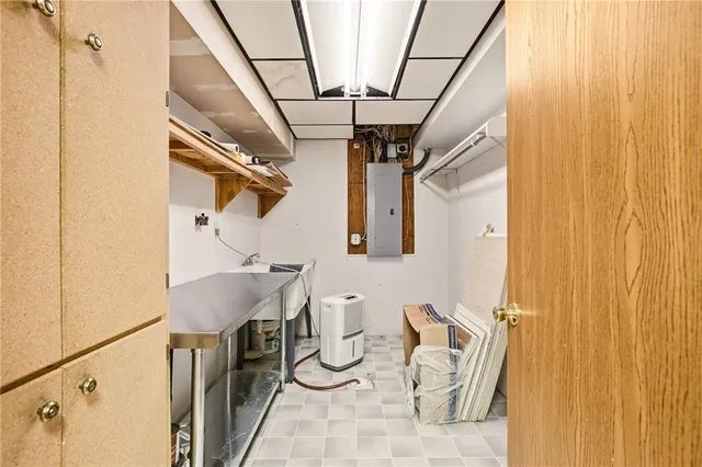 a large white kitchen with a sink and dishwasher a stove with wooden floor