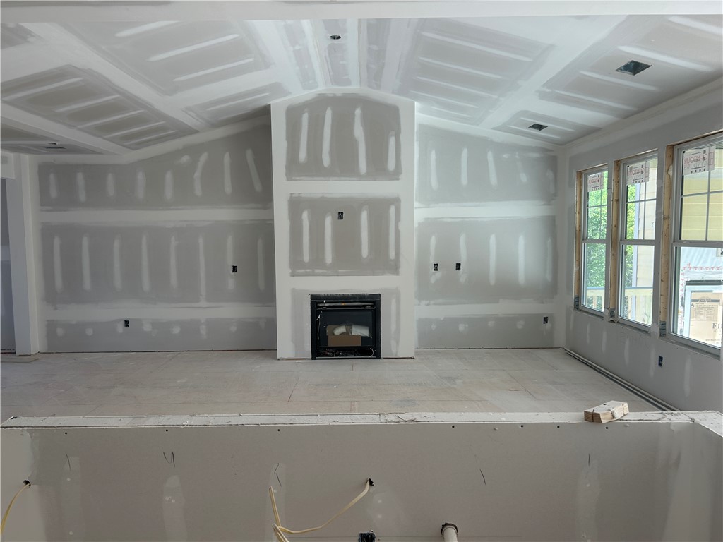 131 Shale Drive Central, SC 29630 - Photo 4 of 9 This newly framed interior space features a central fireplace and large windows.