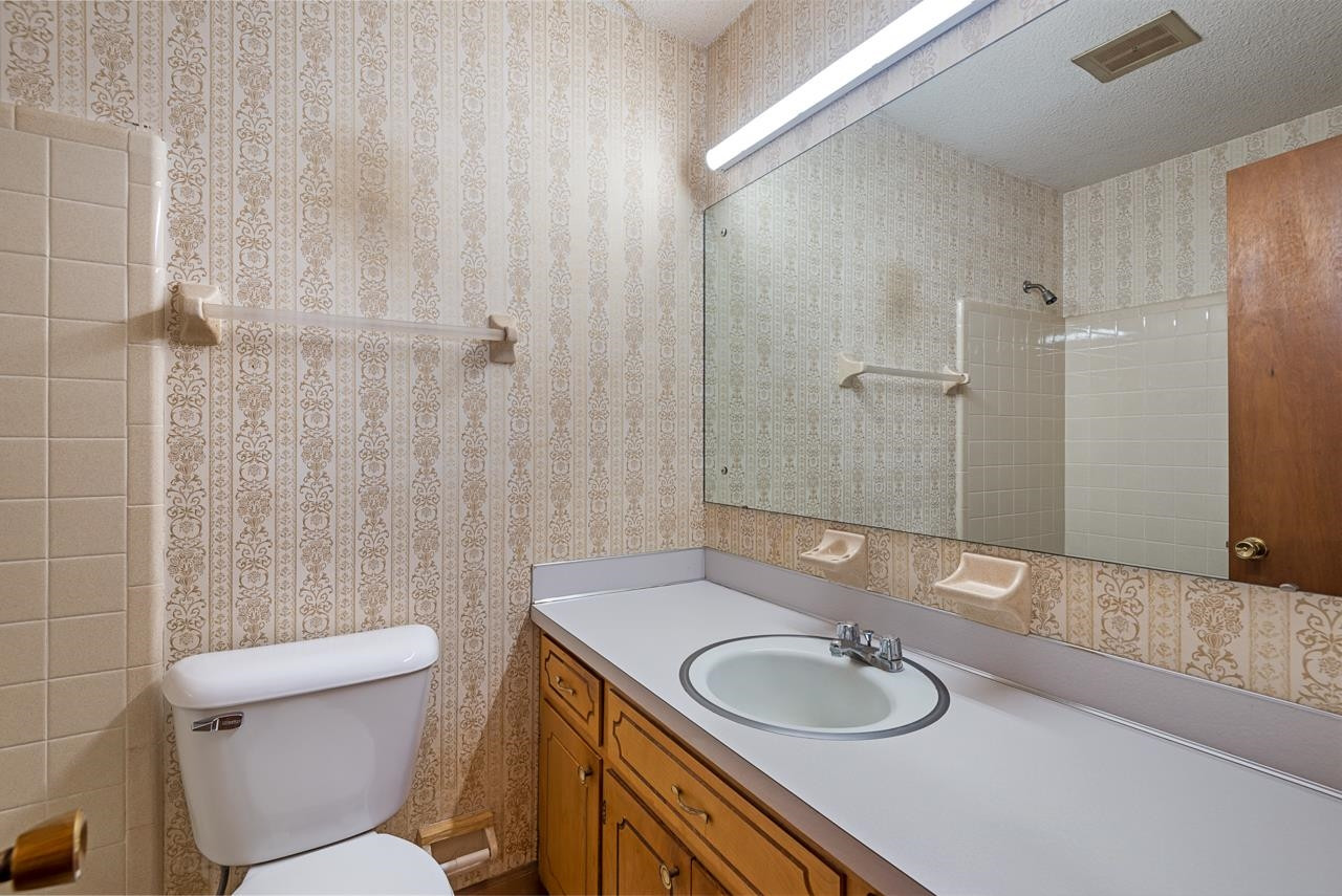 7222 Russell Road Durham, NC 27712 - Photo 12 of 38 a bathroom with a granite countertop sink a toilet a mirror and shower