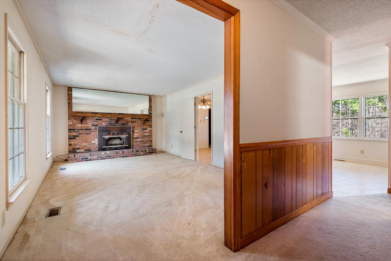 7222 Russell Road Durham, NC 27712 - Photo 4 of 38 an empty room with furniture and a fireplace