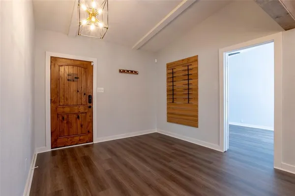 an empty room with wooden floor cabinet and windows