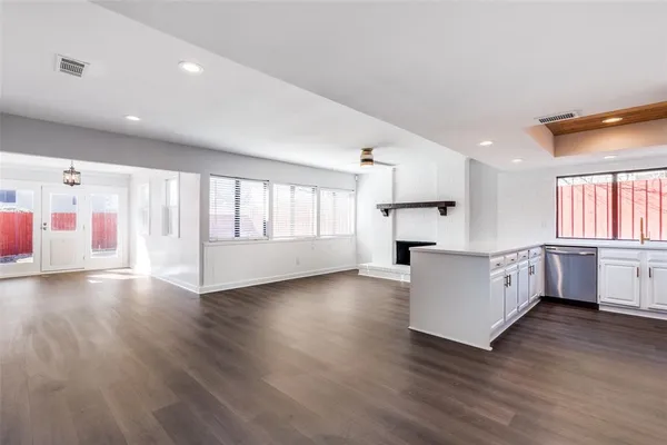a large white kitchen with wooden floors and white cabinets