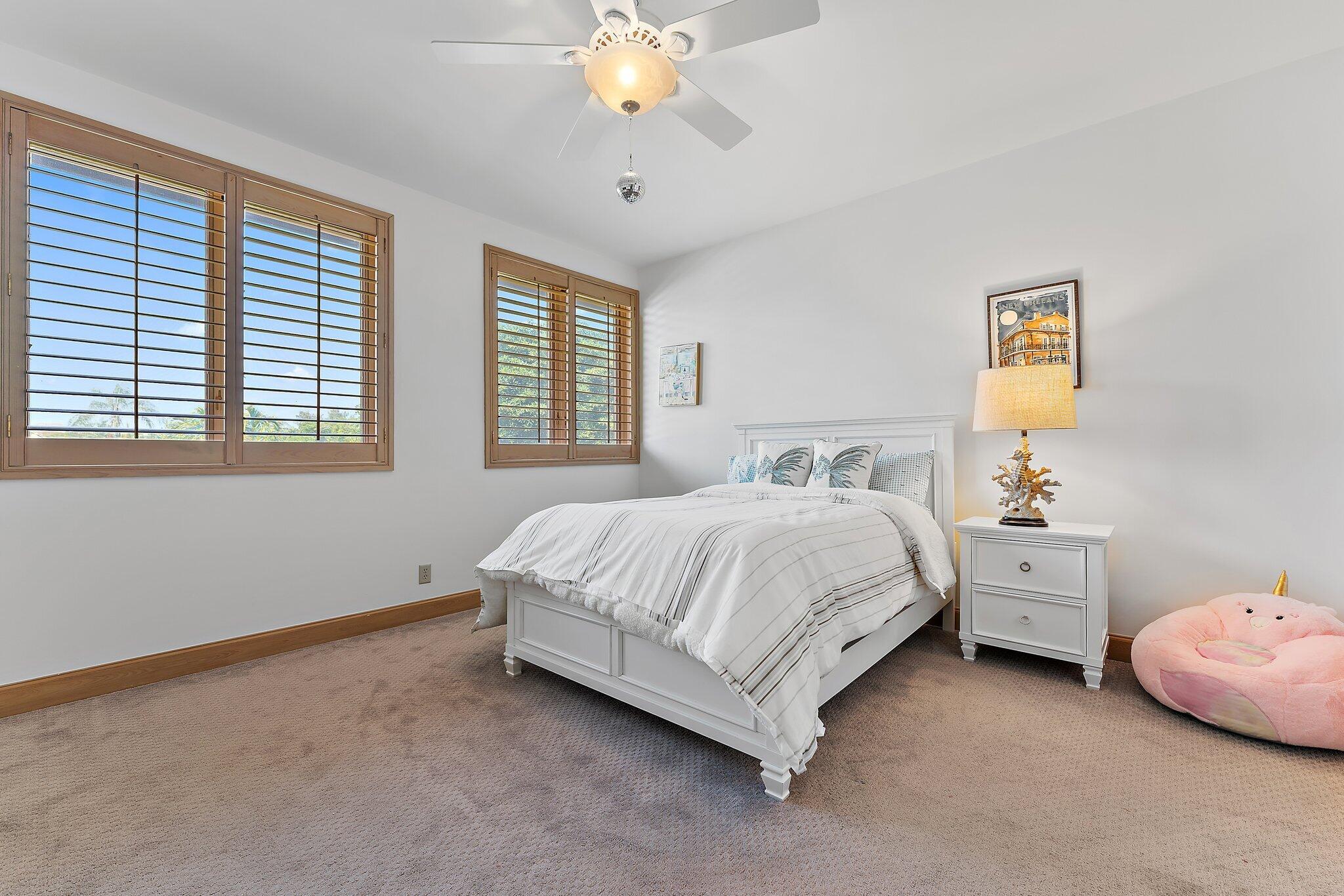 1454 Point Way North Palm Beach, FL 33408 - Photo 30 of 47 a spacious bedroom with a bed and a chandelier