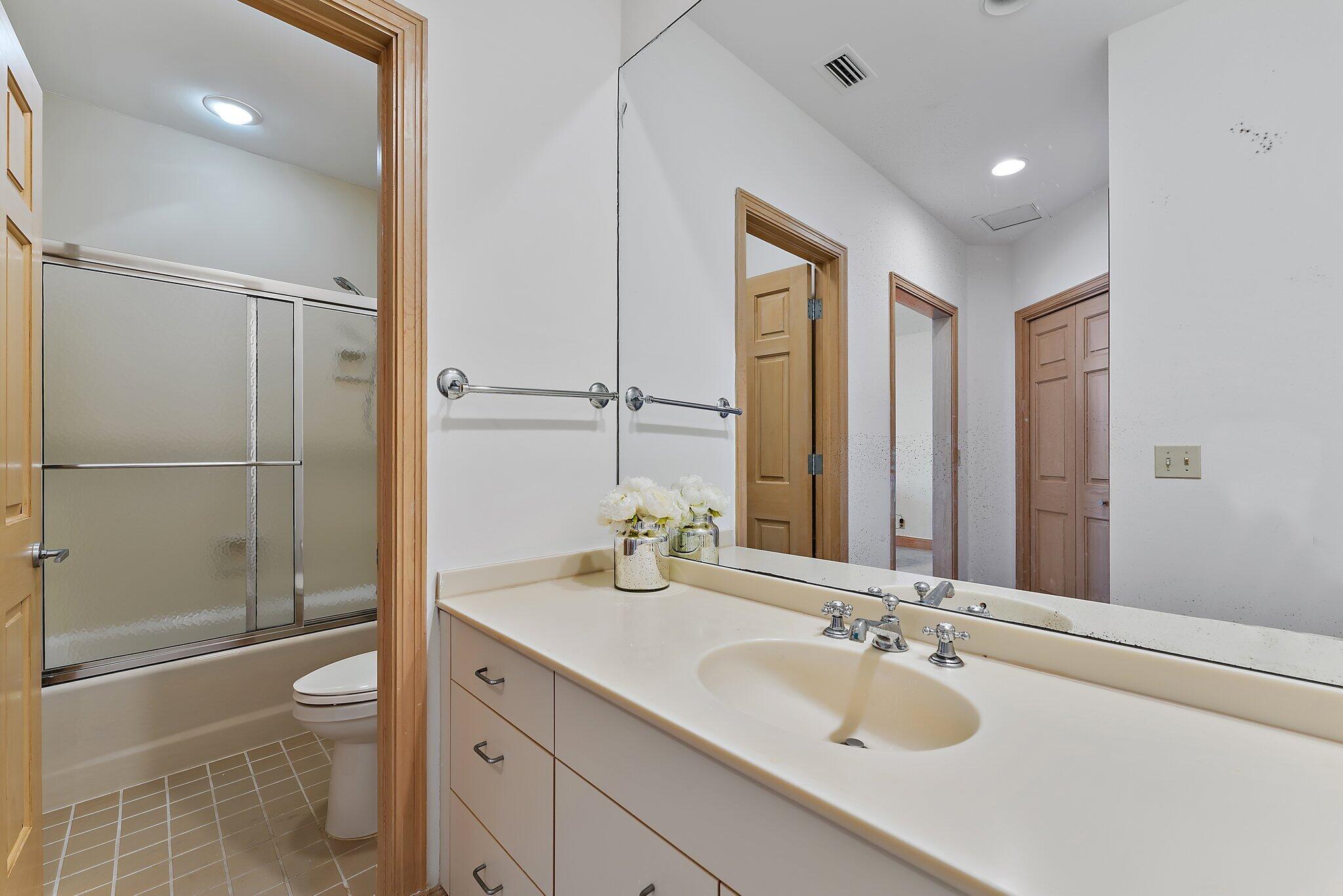 1454 Point Way North Palm Beach, FL 33408 - Photo 31 of 47 a bathroom with a granite countertop sink toilet a mirror and shower