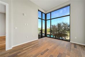 5921 Hiline Road, Unit 1203 Austin, TX 78734 - Photo 16 of 34 Massive corner windows framing leafy views flood this minimalist room with natural light.