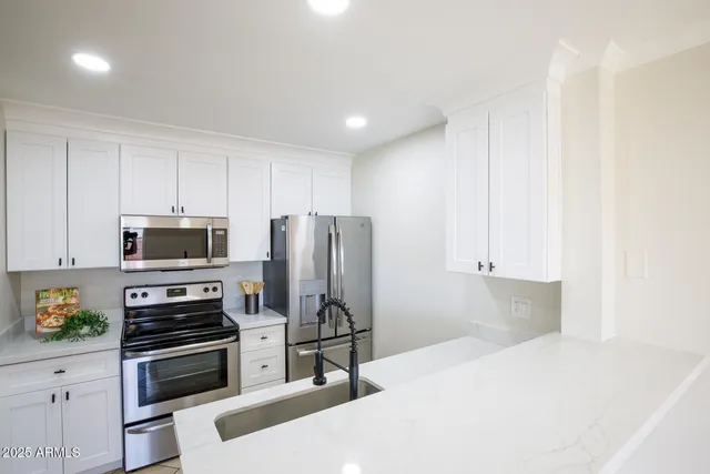 a kitchen with appliances a sink and cabinets