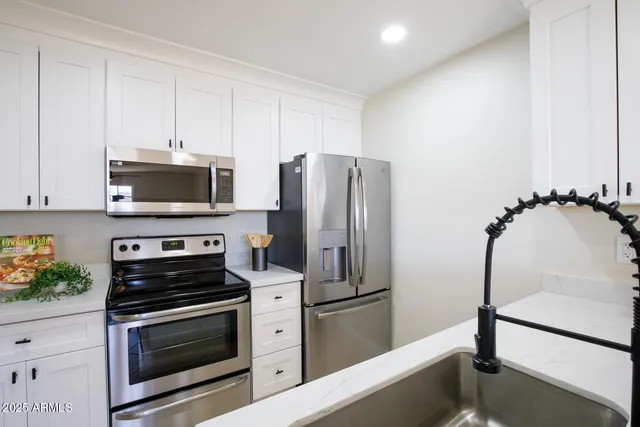 a kitchen with stainless steel appliances a refrigerator stove and microwave