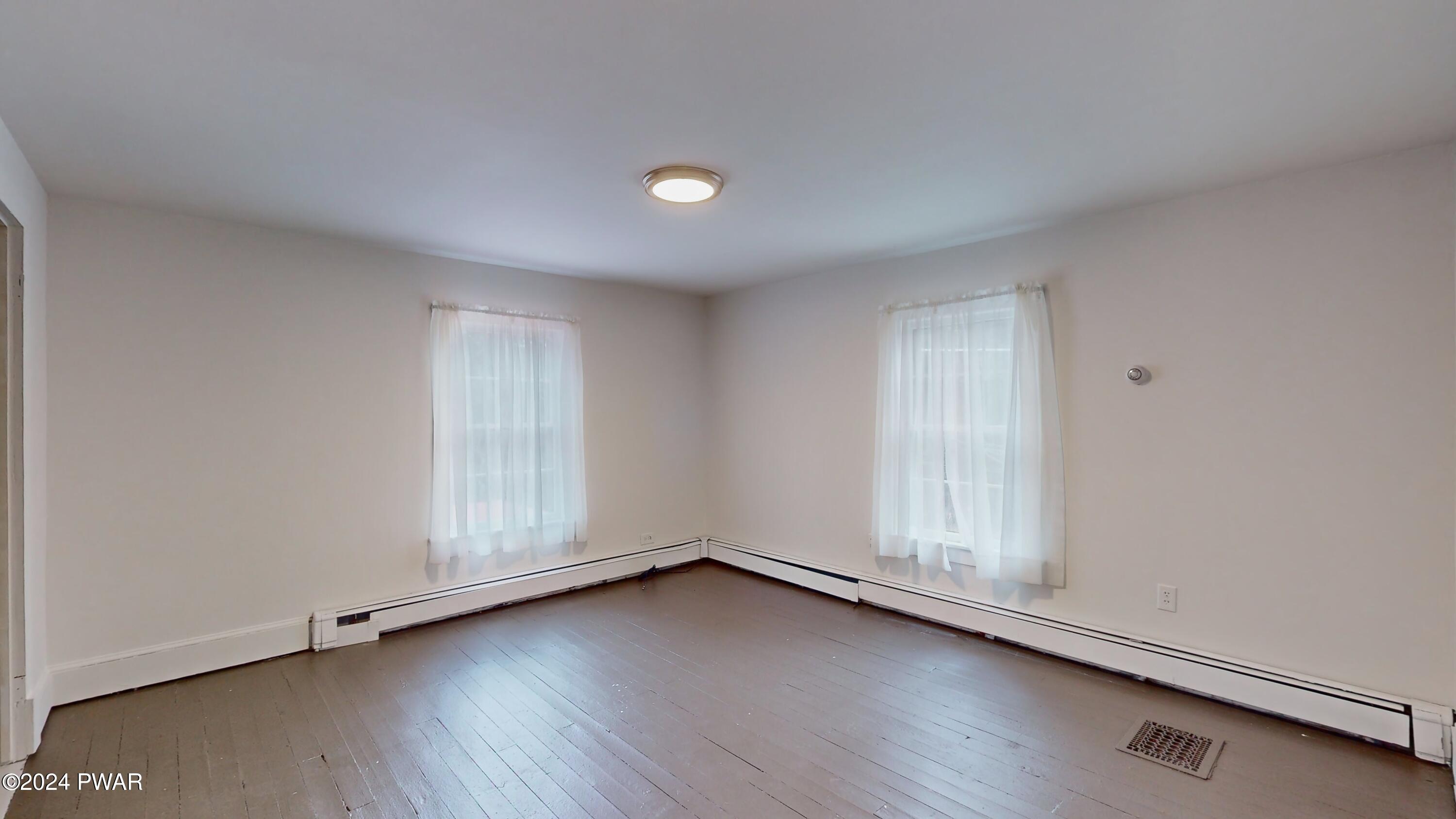 108 9th Street Milford, PA 18337 - Photo 16 of 38 an empty room with wooden floor and window