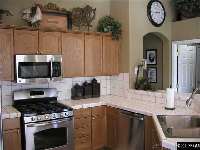 10585 Arbor Way Reno, NV 89521 - Photo 3 of 13 a kitchen with stainless steel appliances a stove a sink and a microwave