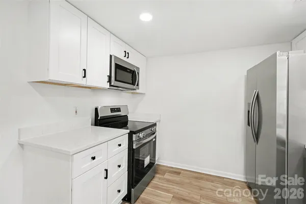 a kitchen with stainless steel appliances white cabinets and a refrigerator