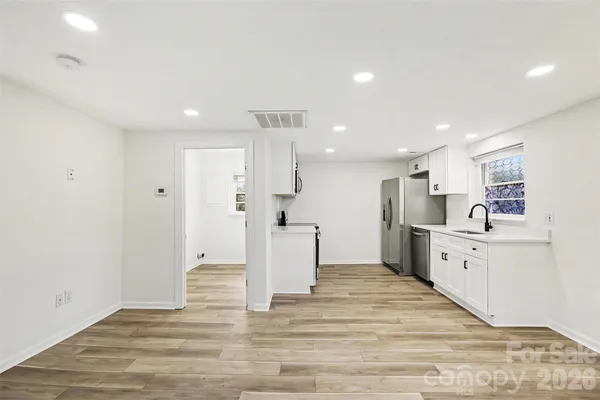 a large white kitchen with white cabinets and stainless steel appliances