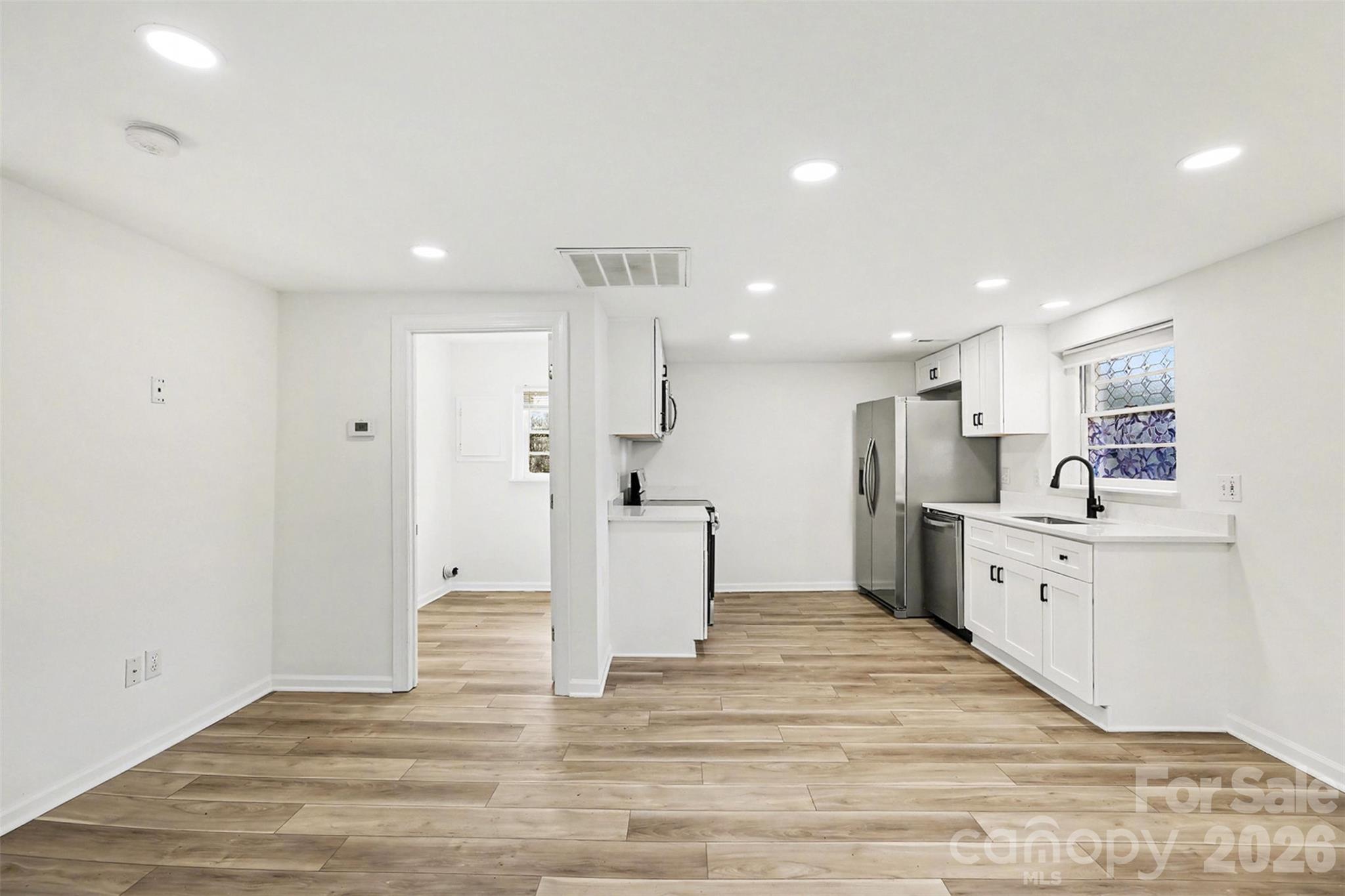 655 Ridgecrest Drive Mooresville, NC 28115 - Photo 12 of 16 a large white kitchen with white cabinets and stainless steel appliances