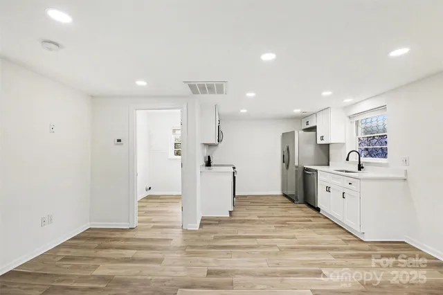 a large white kitchen with white cabinets and stainless steel appliances