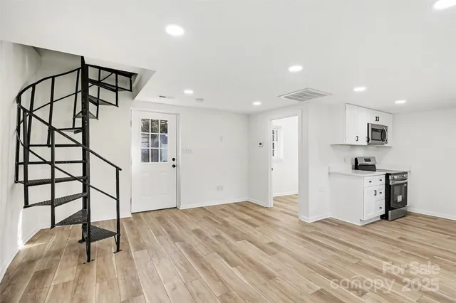 a view of a kitchen with wooden floor and a sink