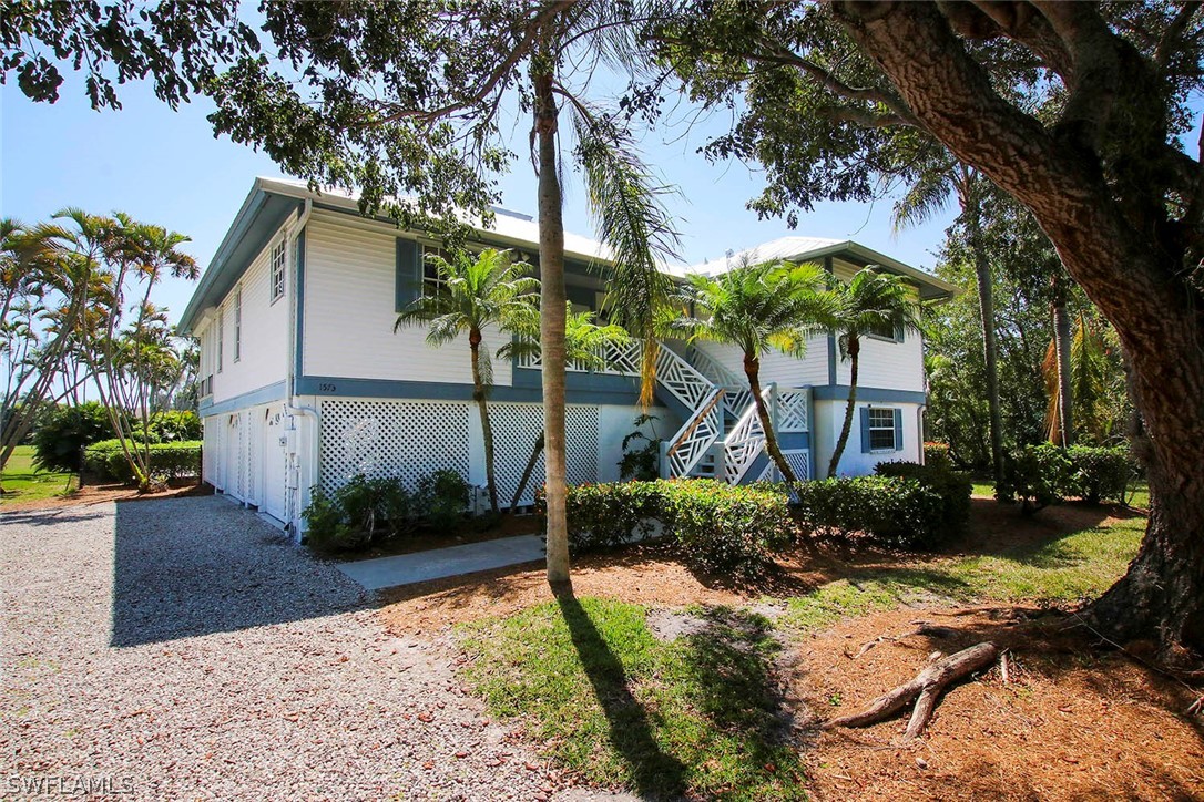 1573 Sand Castle Road Sanibel, FL 33957 - Photo 2 of 31 a front view of a house with garden