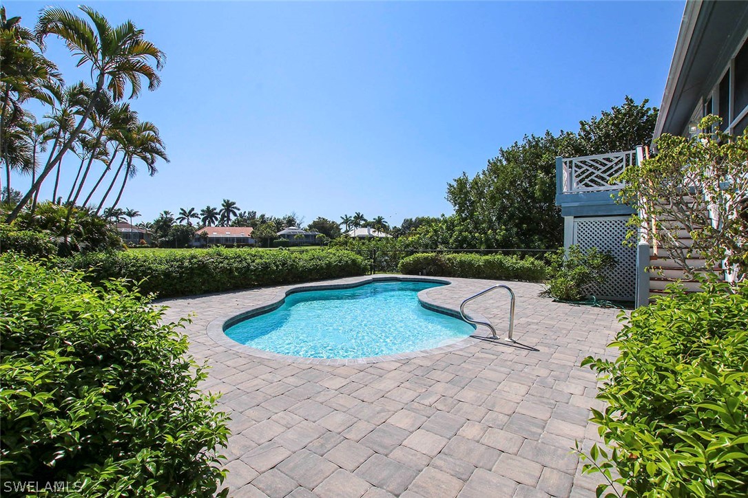 1573 Sand Castle Road Sanibel, FL 33957 - Photo 27 of 31 a view of a swimming pool with a garden