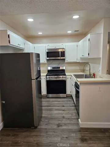 a kitchen with a refrigerator a stove and a sink