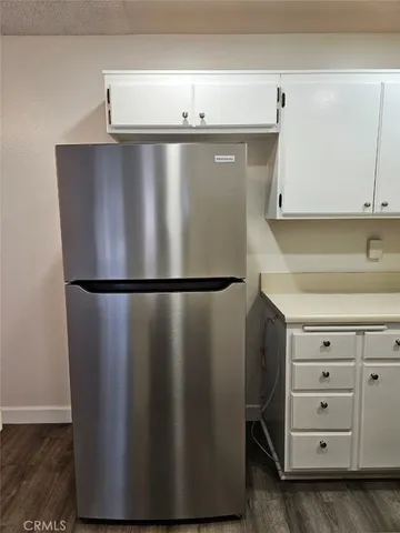 a view of a livingroom with a kitchen counter space wooden floor and a ceiling fan