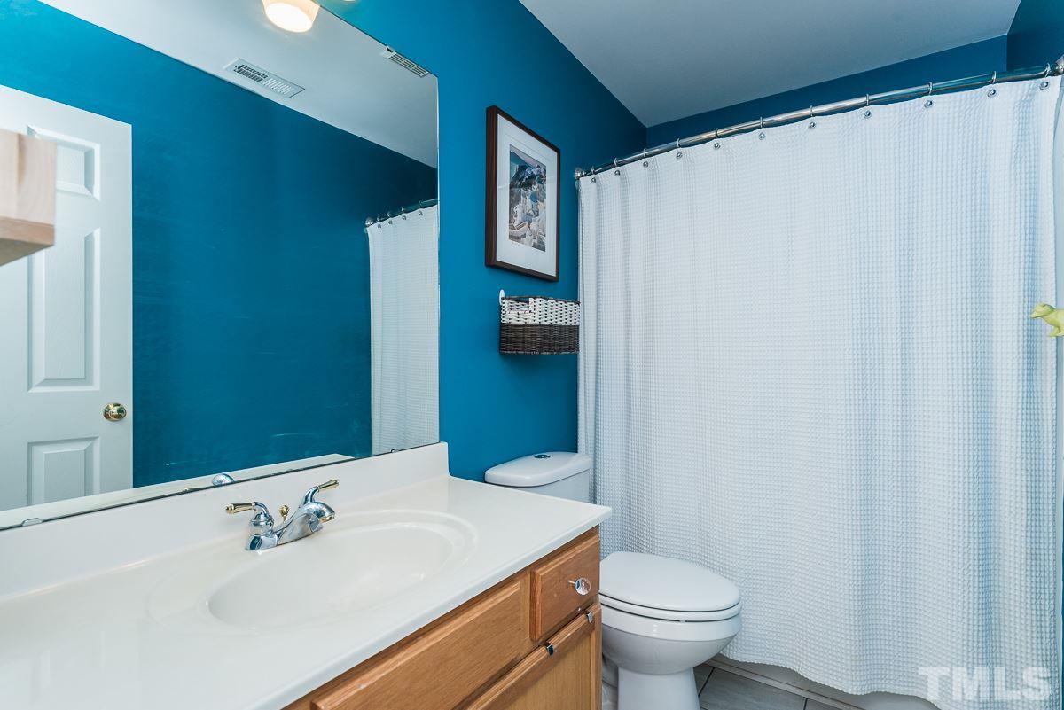 8516 Slabstone Court Raleigh, NC 27613 - Photo 22 of 30 a bathroom with a sink a toilet and shower curtain
